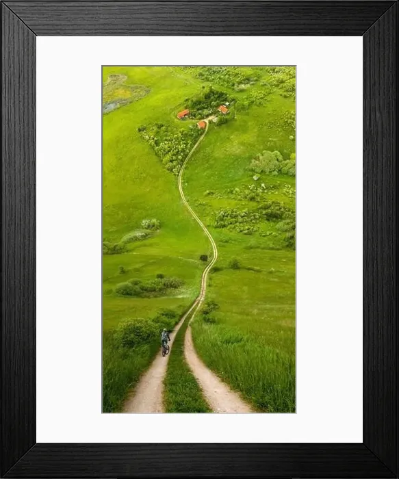 Framed Print : Cyclist on road toward farm amongst meadows in warp perspective, Mazury Poland Framed Print : Cyclist on road toward farm amongst meadows in warp perspective, Mazury Poland