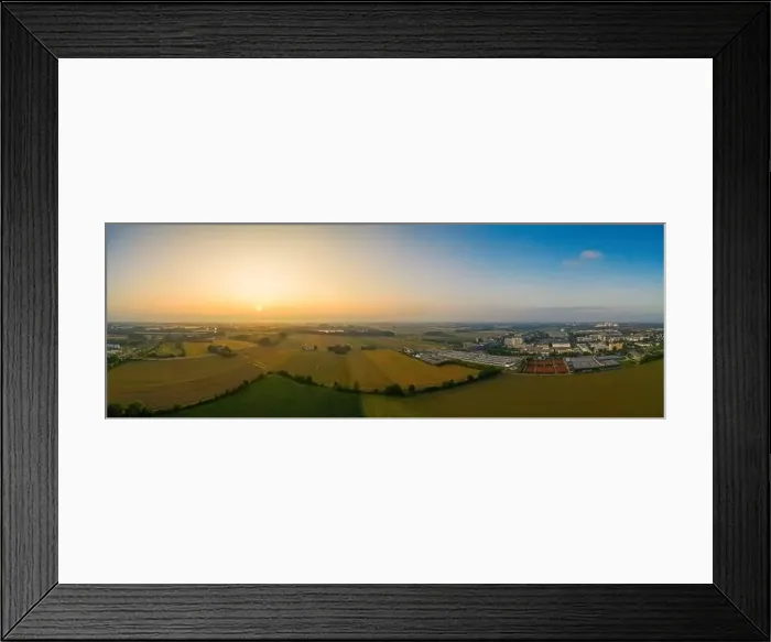 Framed Print : Drone footage - sunrise view over fields and a nearby situated business district Framed Print : Drone footage - sunrise view over fields and a nearby situated business district