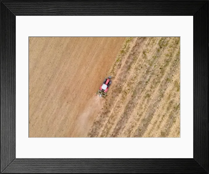 Framed Print : aerial drone view of a tractor plowing in a field Framed Print : aerial drone view of a tractor plowing in a field