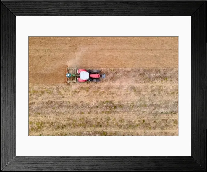 Framed Print : aerial drone view of a tractor plowing in a field Framed Print : aerial drone view of a tractor plowing in a field