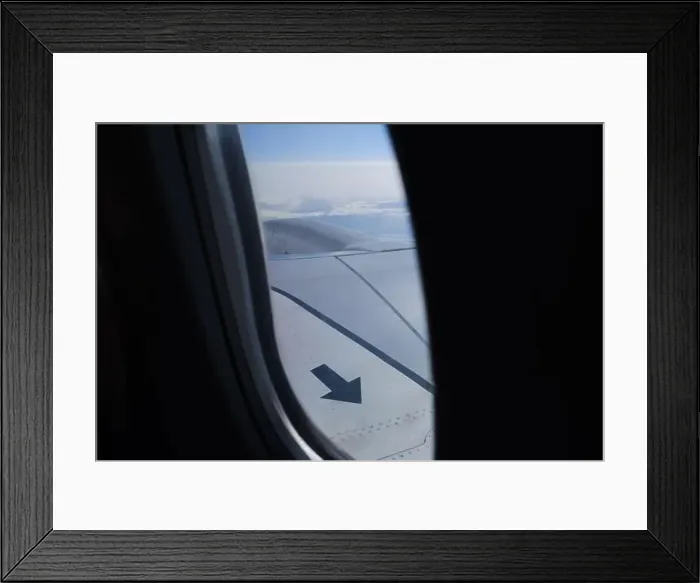 Framed Print : Arrow sign on the airplane wing up in the sky porthole view Framed Print : Arrow sign on the airplane wing up in the sky porthole view