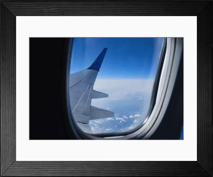 Framed Print : Plane wing in porthole. Aerial sky horizon view from airplane window Framed Print : Plane wing in porthole. Aerial sky horizon view from airplane window