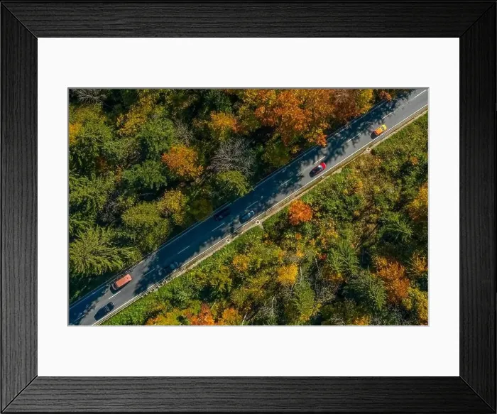 Framed Print : Wonderful colors of the autumn forest crossed by a diagonal asphalt road with driving cars Framed Print : Wonderful colors of the autumn forest crossed by a diagonal asphalt road with driving cars