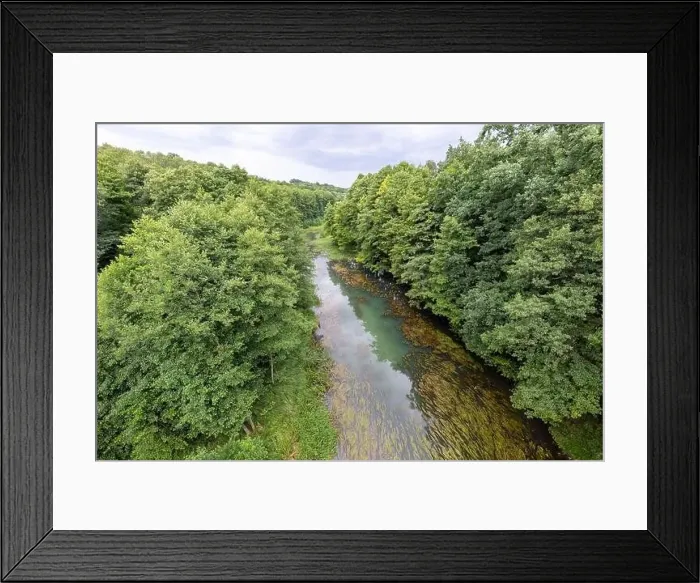Framed Print : A small river seen from the railway bridge. The river bed is covered with deciduous trees. Summer season Framed Print : A small river seen from the railway bridge. The river bed is covered with deciduous trees. Summer season