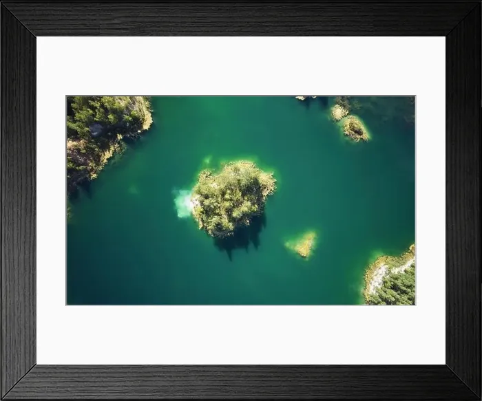 Framed Print : Small island in green lake water aerial above top view