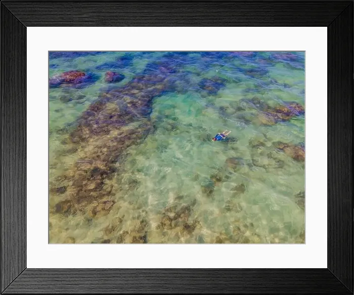 Framed Print : Boy is snorkeling among the corals. View from the drone