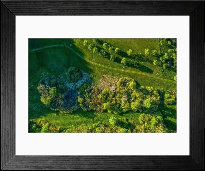 Framed Print : Drone shot at a green countrysided path through grassy meadows, where you can enjoy a healthy walk at the fresh air Framed Print : Drone shot at a green countrysided path through grassy meadows, where you can enjoy a healthy walk at the fresh air