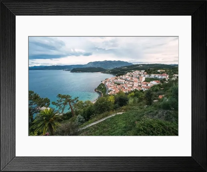 Framed Print : Drone view of peaceful seashore with green trees and small town with red roofs locating near blue sea Framed Print : Drone view of peaceful seashore with green trees and small town with red roofs locating near blue sea