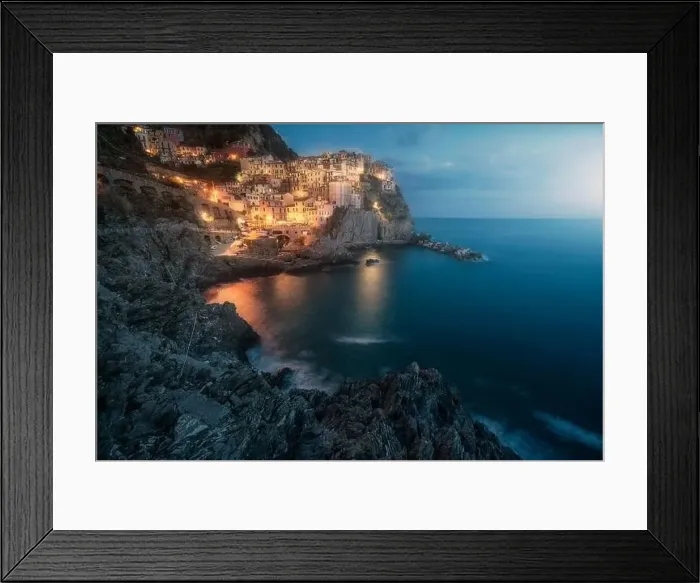 Framed Print : Amazing landscape with small town with colorful lights on rocky coast washing by tranquil ocean water at night Framed Print : Amazing landscape with small town with colorful lights on rocky coast washing by tranquil ocean water at night