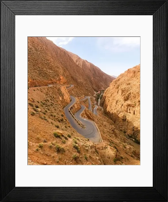 Framed Print : From above of majestic landscape of narrow winding roadway going between rough rocks against blue sky Framed Print : From above of majestic landscape of narrow winding roadway going between rough rocks against blue sky