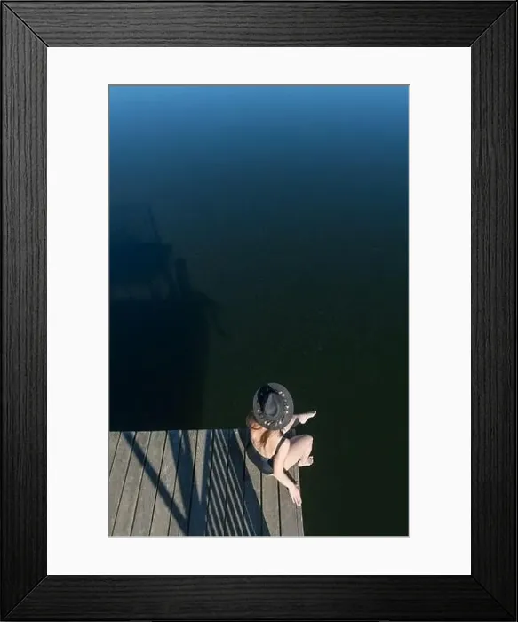 Framed Print : Top view of unrecognizable thoughtful Woman in black swimsuit and hat sitting on wooden pier Framed Print : Top view of unrecognizable thoughtful Woman in black swimsuit and hat sitting on wooden pier