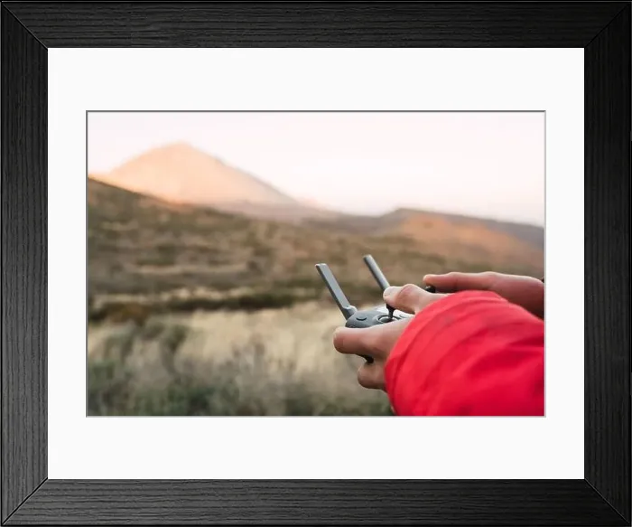 Framed Print : Side view of human holding joystick on land near top of mountain Teide in Tenerife, Canary Islands, Spain