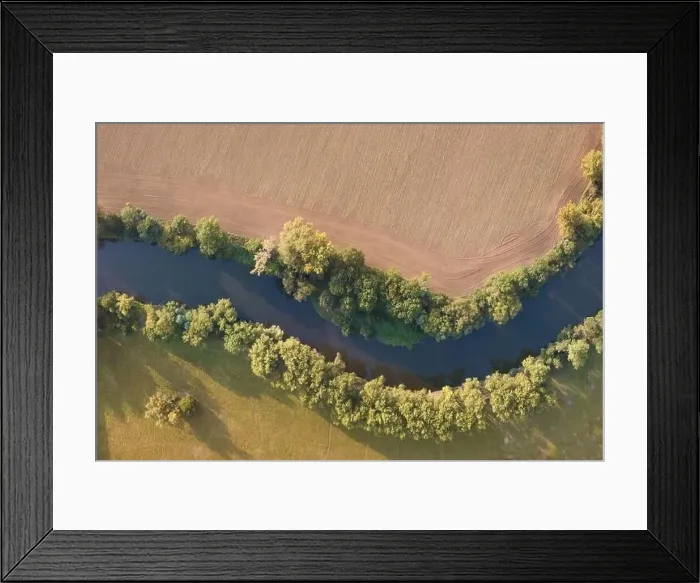 Framed Print : Top view of the river with turns of meanders and green forests in bright sunlight Framed Print : Top view of the river with turns of meanders and green forests in bright sunlight