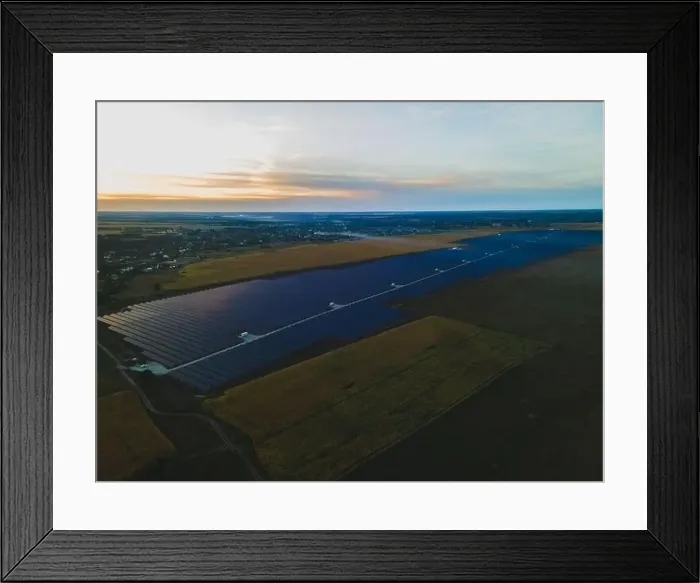 Framed Print : Aerial drone view into large solar panels at a solar farm in large field on countryside at bright sunset