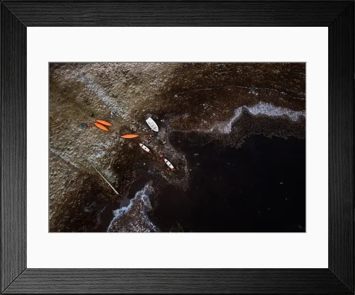 Framed Print : Drone view of kayaks located on frozen shore of pond in winter in Scottish Highlands Framed Print : Drone view of kayaks located on frozen shore of pond in winter in Scottish Highlands