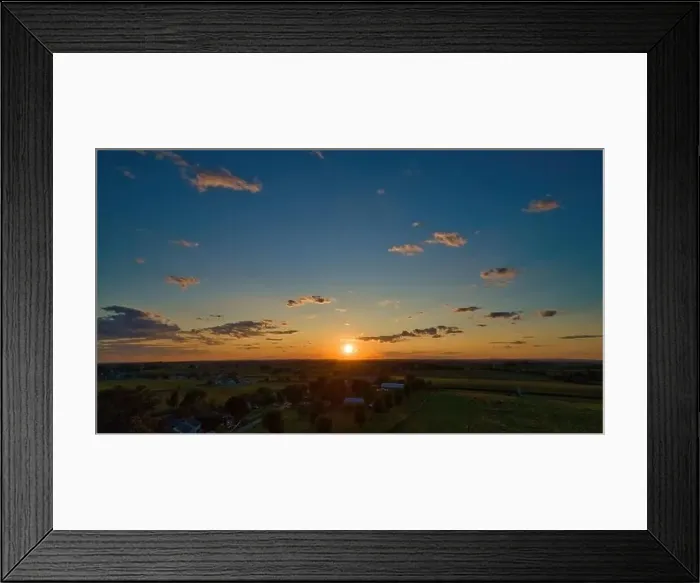 Framed Print : Sunset over barns, silos and green farmlands with blue, red and orange skies and a few clouds Framed Print : Sunset over barns, silos and green farmlands with blue, red and orange skies and a few clouds