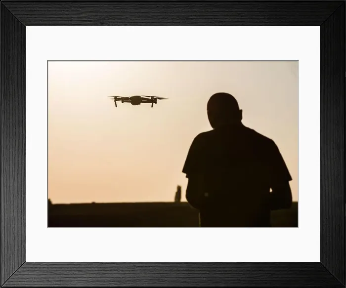 Framed Print : Color image of a man flying a drone at sunrise Framed Print : Color image of a man flying a drone at sunrise