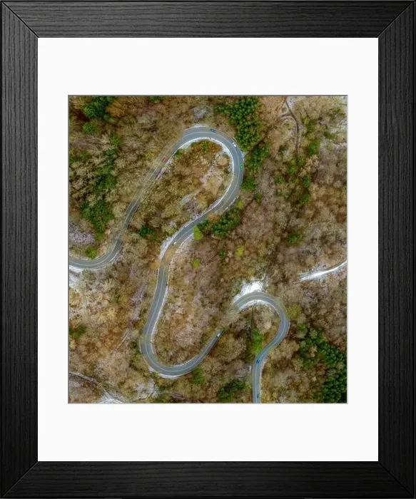 Framed Print : Winding road in the transition from autumn to winter, snow at a germany roa, filmed straight from above Framed Print : Winding road in the transition from autumn to winter, snow at a germany roa, filmed straight from above