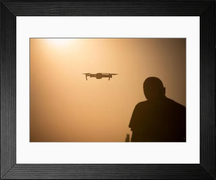 Framed Print : Color image of a man flying a drone at sunrise Framed Print : Color image of a man flying a drone at sunrise