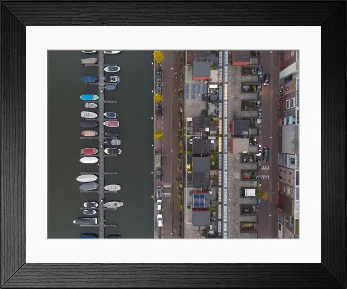 Framed Print : Aerial shot of an urban area houses next to the water with small docks boats Framed Print : Aerial shot of an urban area houses next to the water with small docks boats