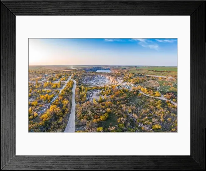 Framed Print : Extraction of minerals with the help of special equipment near a small lake in the warm evening light in picturesque Framed Print : Extraction of minerals with the help of special equipment near a small lake in the warm evening light in picturesque