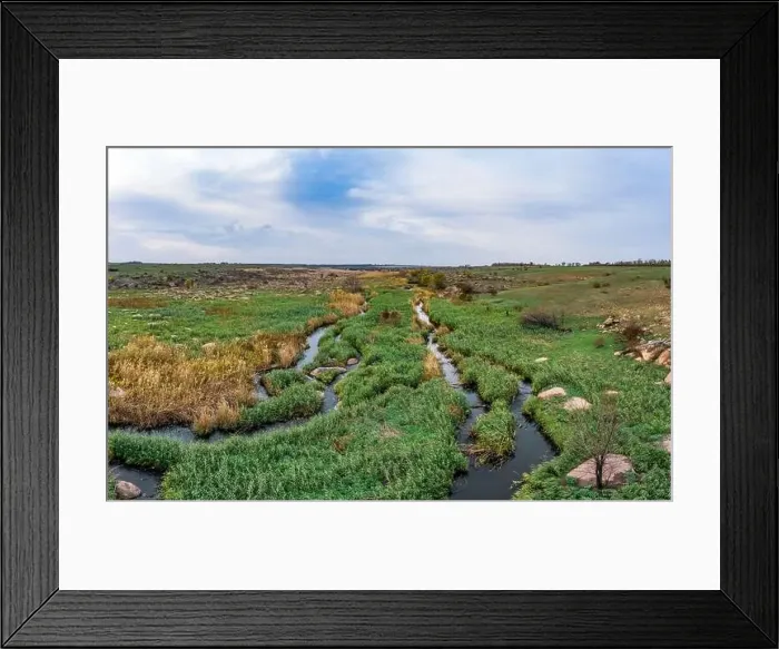 Framed Print : A small fast stream Kamenka in the wilderness in the evening light in Ukraine. Aerial panoramic drone shot