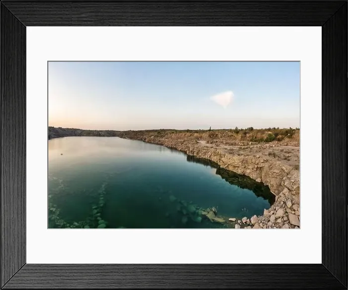 Framed Print : Old flooded stone quarry with large stones in the evening warm bright light covered with small dry plants in Framed Print : Old flooded stone quarry with large stones in the evening warm bright light covered with small dry plants in