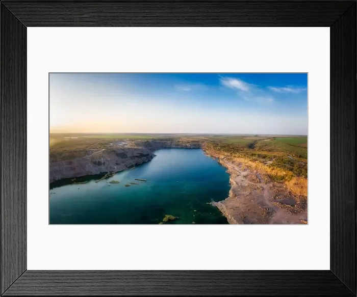Framed Print : Old flooded stone quarry with large stones in the evening warm bright light covered with small dry plants in Framed Print : Old flooded stone quarry with large stones in the evening warm bright light covered with small dry plants in