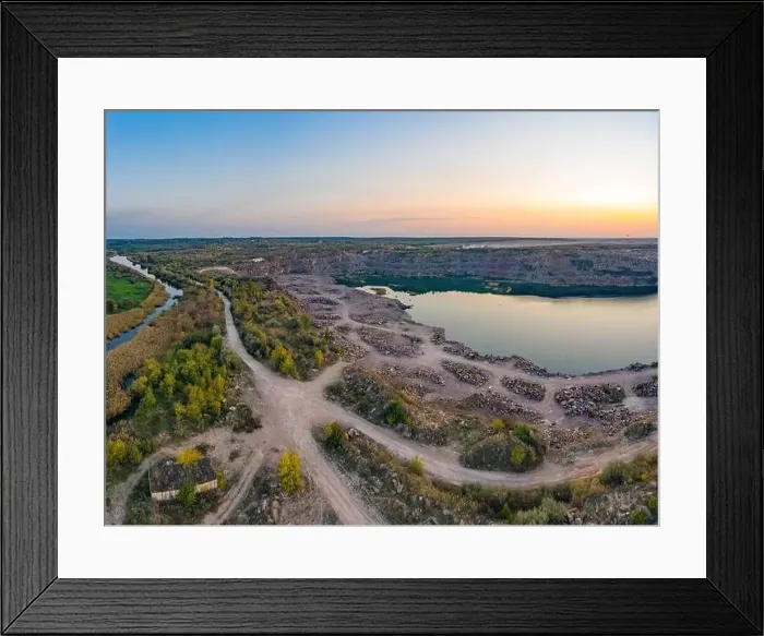 Framed Print : Old flooded stone quarry with large stones in the evening warm bright light covered with small dry plants in Framed Print : Old flooded stone quarry with large stones in the evening warm bright light covered with small dry plants in
