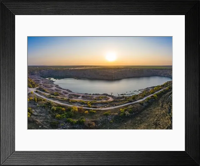 Framed Print : Old flooded stone quarry with large stones in the evening warm bright light covered with small dry plants in Framed Print : Old flooded stone quarry with large stones in the evening warm bright light covered with small dry plants in