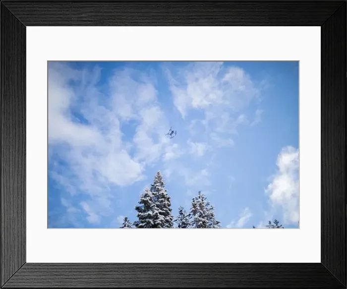 Framed Print : Drone flying over beautiful snowy forest under a blue sky Framed Print : Drone flying over beautiful snowy forest under a blue sky