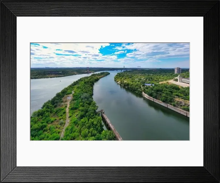 Framed Print : The beautiful river is surrounded by green and fresh vegetation in the city Framed Print : The beautiful river is surrounded by green and fresh vegetation in the city