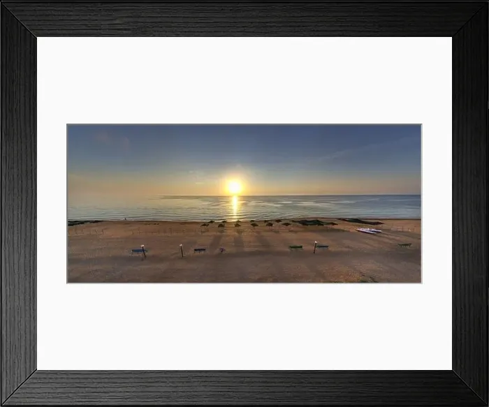 Framed Print : Beach umbrellas at sunrise. Sea current swims against the waves on the beautiful sea