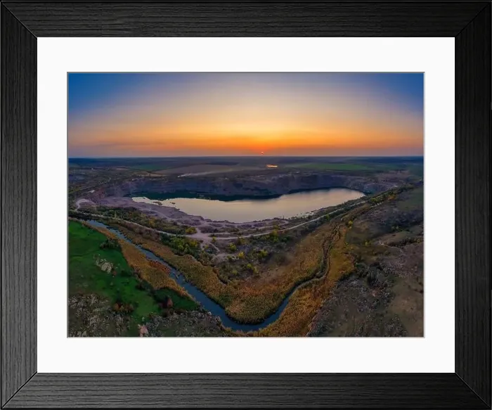Framed Print : Old flooded stone quarry with large stones in the evening warm bright light covered with small dry plants in Framed Print : Old flooded stone quarry with large stones in the evening warm bright light covered with small dry plants in
