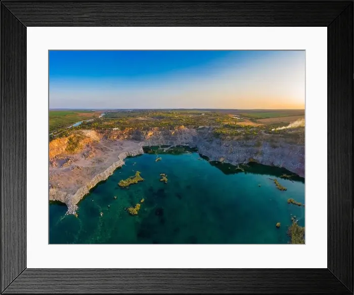 Framed Print : Old flooded stone quarry with large stones in the evening warm bright light covered with small dry plants in Framed Print : Old flooded stone quarry with large stones in the evening warm bright light covered with small dry plants in