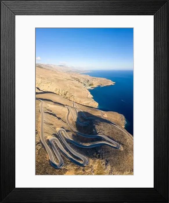 Framed Print : Aerial coastal view of the winding road between the towns of Hora Skafion and Anopolis on the south coast of Crete