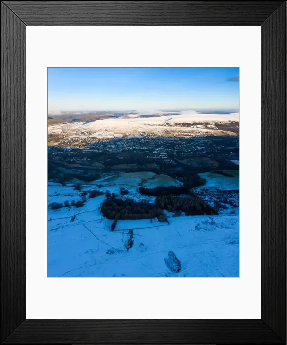 Framed Print : Aerial drone view of snow covered mountains and towns rising above the south east valleys, Wales Framed Print : Aerial drone view of snow covered mountains and towns rising above the south east valleys, Wales