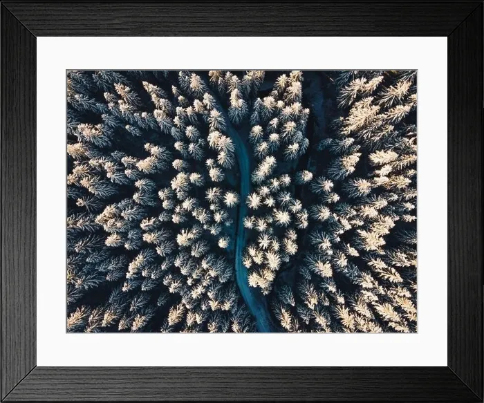 Framed Print : High quality aerial photo of a road leading through the deep forest covered in the snow in the central Europe