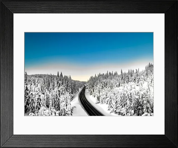 Framed Print : Highway with cars driving through a mountain pass with snow covered trees Framed Print : Highway with cars driving through a mountain pass with snow covered trees