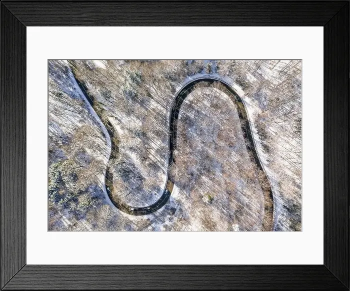 Framed Print : Cars on a double curve street in winter with snow covered trees. Aerial view at a wonderful snowy white landscape Framed Print : Cars on a double curve street in winter with snow covered trees. Aerial view at a wonderful snowy white landscape