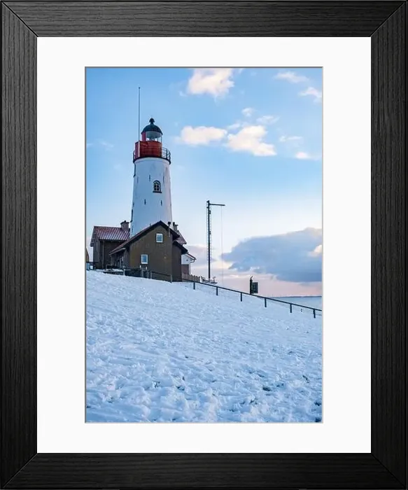 Framed Print : Urk Netherlands lighthouse during winter with snow covered coastline