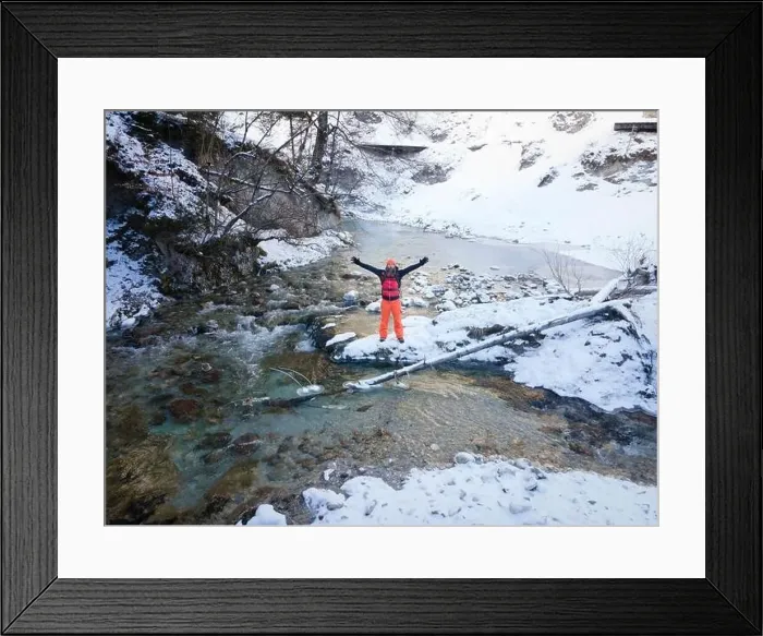 Framed Print : Aerial drone shot of hiker with backpack, orange cap and orange pants next to cold mountain stream in canyon Framed Print : Aerial drone shot of hiker with backpack, orange cap and orange pants next to cold mountain stream in canyon