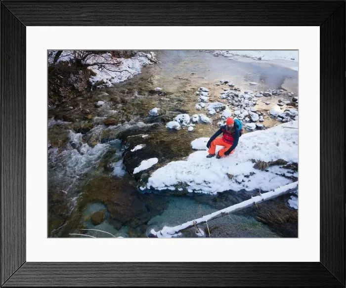 Framed Print : Aerial drone shot of hiker with backpack, orange cap and orange pants next to cold mountain stream in canyon Framed Print : Aerial drone shot of hiker with backpack, orange cap and orange pants next to cold mountain stream in canyon