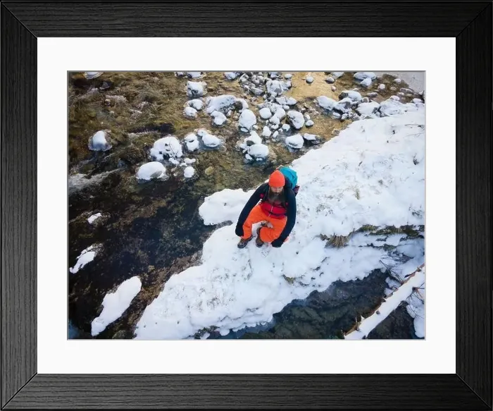 Framed Print : Aerial drone shot of hiker with backpack, orange cap and orange pants next to cold mountain stream in canyon Framed Print : Aerial drone shot of hiker with backpack, orange cap and orange pants next to cold mountain stream in canyon