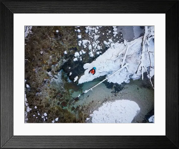 Framed Print : Aerial drone shot of hiker with backpack, orange cap and orange pants next to cold mountain stream in canyon Framed Print : Aerial drone shot of hiker with backpack, orange cap and orange pants next to cold mountain stream in canyon