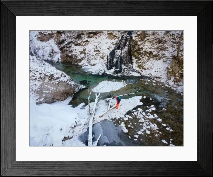 Framed Print : Aerial drone shot of hiker with backpack, orange cap and orange pants next to cold mountain stream in canyon Framed Print : Aerial drone shot of hiker with backpack, orange cap and orange pants next to cold mountain stream in canyon