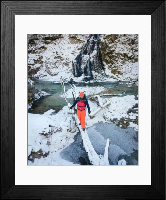 Framed Print : Aerial drone shot of hiker with backpack, orange cap and orange pants next to cold mountain stream in canyon Framed Print : Aerial drone shot of hiker with backpack, orange cap and orange pants next to cold mountain stream in canyon
