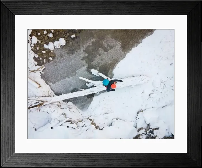 Framed Print : Aerial drone shot of hiker with backpack, orange cap and orange pants next to cold mountain stream in canyon Framed Print : Aerial drone shot of hiker with backpack, orange cap and orange pants next to cold mountain stream in canyon