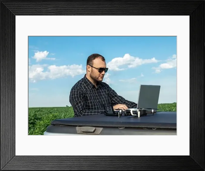 Framed Print : Farmer standing in soybean field looking at notebook and drone Framed Print : Farmer standing in soybean field looking at notebook and drone