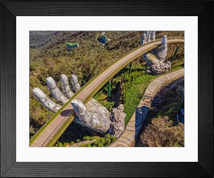 Framed Print : Top aerial view of the famous Golden Bridge is lifted by two giant hands in the tourist resort on Ba Na Hill in Da Nang Framed Print : Top aerial view of the famous Golden Bridge is lifted by two giant hands in the tourist resort on Ba Na Hill in Da Nang